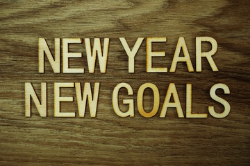 New Year New Goals text message on wooden background