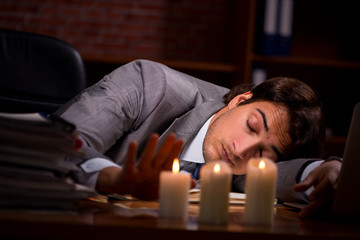 Businessman working late in office with candle light