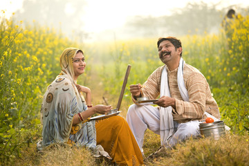 Rural couple having lunch break on agriculture field