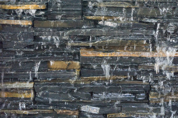Waterfall with stone wall,beautyful abstract background and pattern,dribble water,black stone