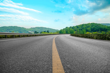 Fototapeta premium Empty asphalt road and natural landscape under the blue sky