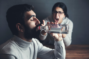 angry woman with alcohol bottle man