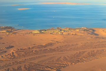 Obraz premium Aerial view on Red sea, Arabian desert and touristic resort near Hurghada, Egypt. View from airplane