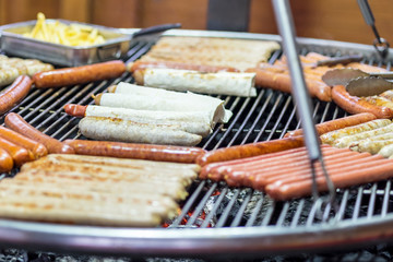 sausages are grilled over charcoal