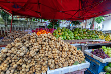 Street counter with tropical vegetables and fruits in a typical Asian market, Southeast Asia, Laos