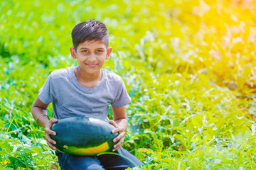 young indian farmer at watermelon field\