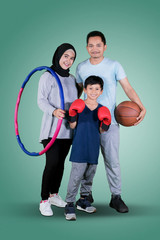 Happy family holding different sports equipment