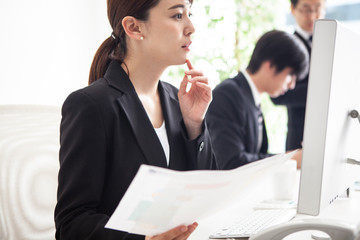 書類を確認しながらデータ入力をおこなう女性会社員