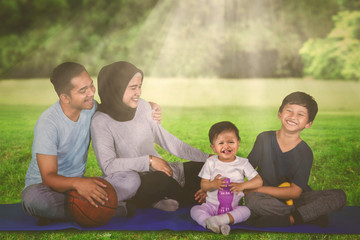 Muslim family rests after exercise in the park