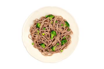 A plate of buckwheat noodles with green vegetables, shot from the top, isolated on a white background with a clipping path