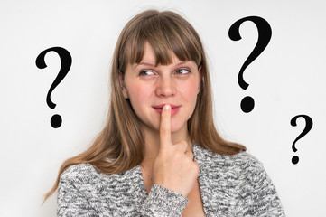 Woman with finger on her lips and question marks