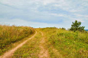 Fototapeta na wymiar A simple field road on the autumn day