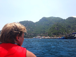 Fototapeta premium Big man on a rubber motor boat in the sea and splashing water. Taking pictures from the boat