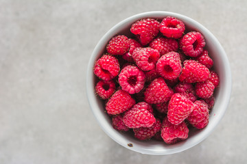 Fresh raspberry, closeup in a bowl, top view