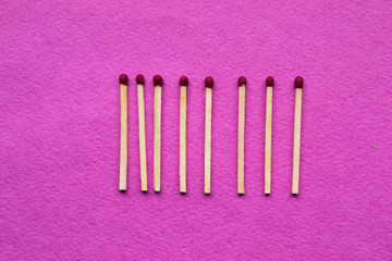matchsticks on a pink background are in a row