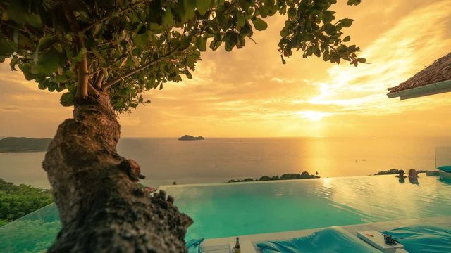 Unidentified people take their holiday in Infinity pool view at the sunset time. Bluerama in Koh Phangan, Thailand - Jule 2018. Timelapse 4K