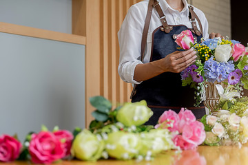 Woman hands making flower composition at florist workshop. Do it yourself concept