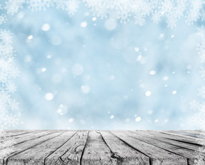 a wooden table and winter snow background with snowflakes