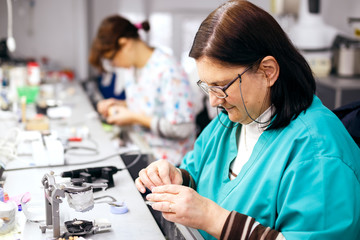 Fototapeta premium Female dental technician working on a dental prosthesis in the dental lab