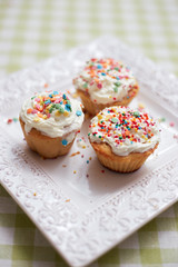 Small Easter cakes are  on the plate on the table in the light kitchen