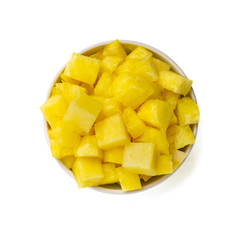 bowl of pineapple pieces isolated on white background. Top view