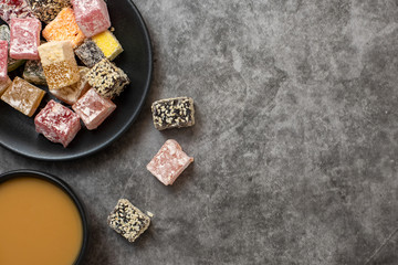 Turkish delight and cup of coffee on grey background. Flat lay. With copy space