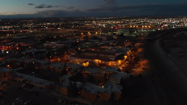 Aerial Shot showing the city lights of Albuquerque, NM as the sun is finishing setting.