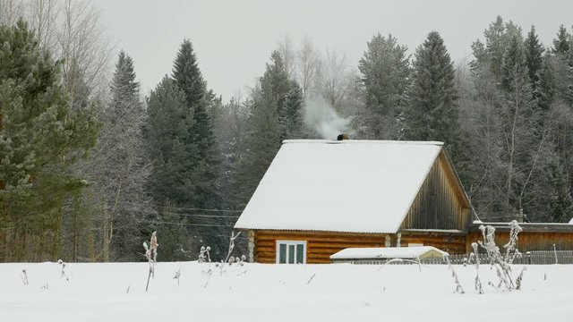Mastering the wild lands. Human vital activity. Human simple homes. Smoke comes from the chimney. Winter period.