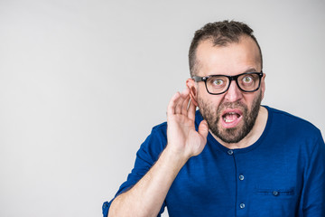 Man eavesdropping with hand close to ear