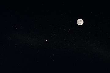 Huge full moon on the night black sky with bright stars.