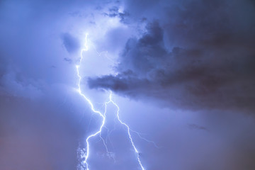Naklejka na ściany i meble Closeup of lightning strike on the night cloudy sky.
