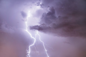 Naklejka na ściany i meble Closeup of lightning strike on the night cloudy sky.