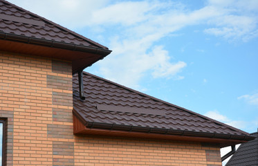 House metal roof corner with rain gutter pipeline. Guttering.