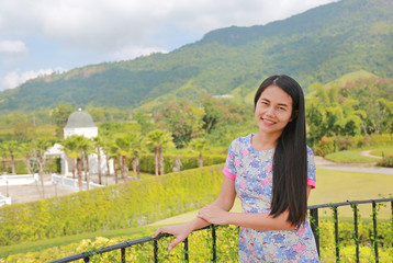 Beautiful Asian woman relax on balcony at hillside with looking camera.