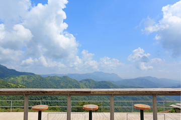 Row of stools at landscape viewpoint of terrace at sunny day with cloud and blue sky.