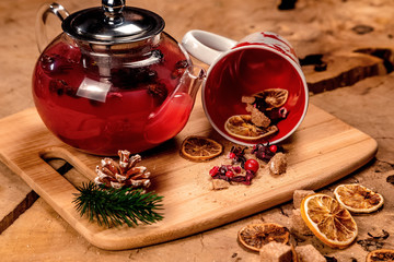 composition teapot with tea, a mug with a deer, dried oranges, berries