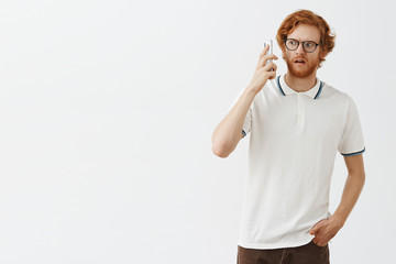 Intense man cannot understand who picked up phone. Portrait of confused stunned and unsure redhead...