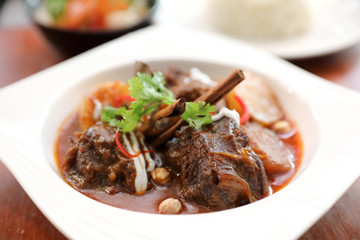 Beef massaman curry with rice and salad on wooden background , Thai food