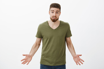 Fototapeta premium What I did wrong, explain. Portrait of confused and desperate clingy boyfriend begging ex come back, raising eyebrows questioned and spread hands sideways cannot understand why she dump him