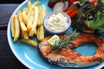 Roasted salmon steak , baked salmon with salad fresh vegetable pm wooden table