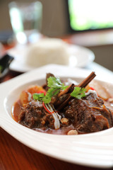 Beef massaman curry with rice and salad on wooden background , Thai food