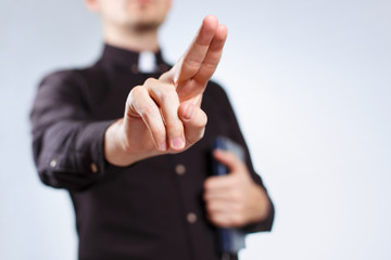 Priest making a blessing gesture on neutral background