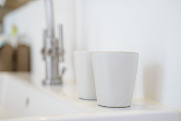 white ceramic cups in blurred bathroom background