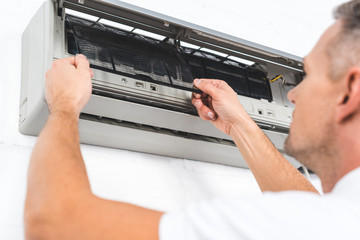 Obraz premium close up view of man fixing filter of air conditioner