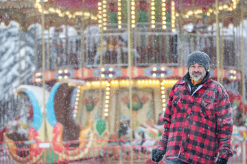 man in a warm jacket near the Victorian carousel