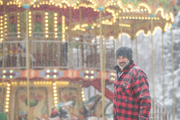 man in a warm jacket near the Victorian carousel