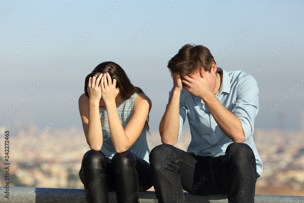 Wall mural Sad couple complaining after argument outdoors