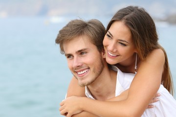 Happy couple in love with perfect smile on the beach