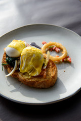 Poached egg with hollandaise sauce on toast with salmon ham and spinach