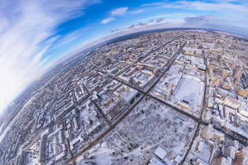 Round panorama aerial view on a winter city under a blue sky with white clouds: rows of streets...